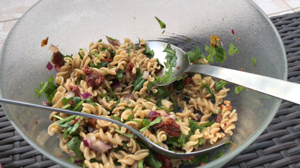 Halb leere Schüssel mit dem fertigen Nudelsalat. 